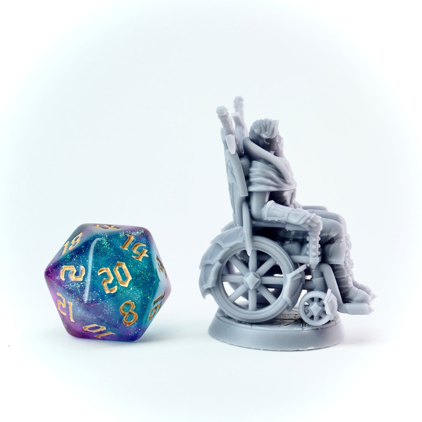 Gray wheelchair figurine and a colorful polyhedral dice on a white background
