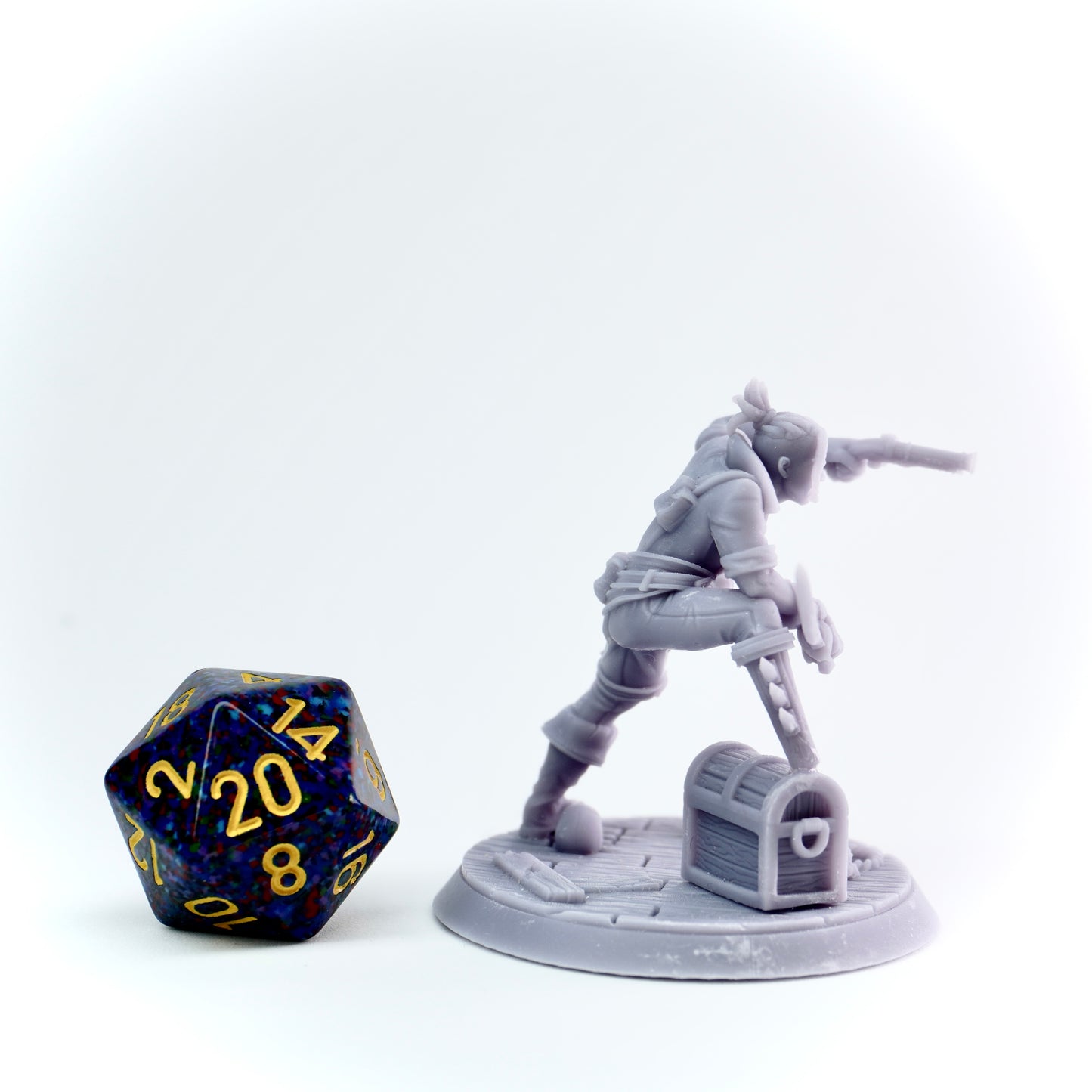 Gray miniature figure of a character with a weapon next to a large polyhedral dice on a white background