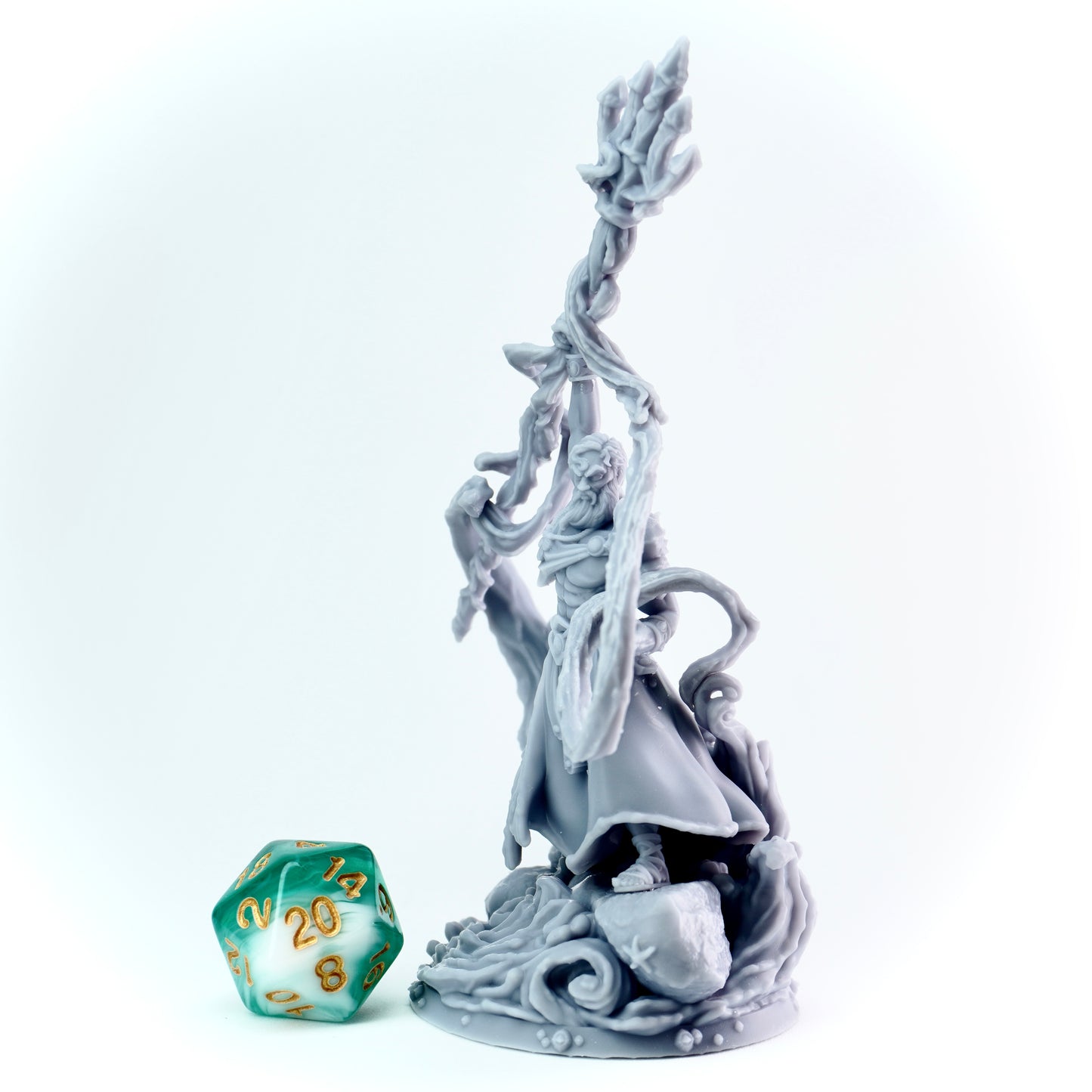 Gray figurine of a warrior with a trident, next to a green polyhedral dice on a white background