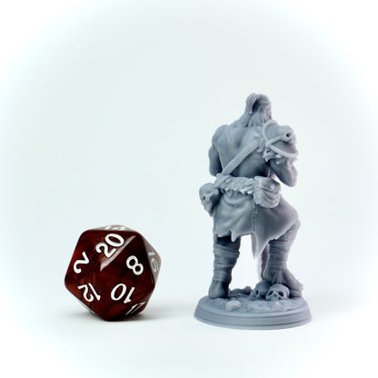 Gray miniature figure of a warrior with a large polyhedral dice on a white background