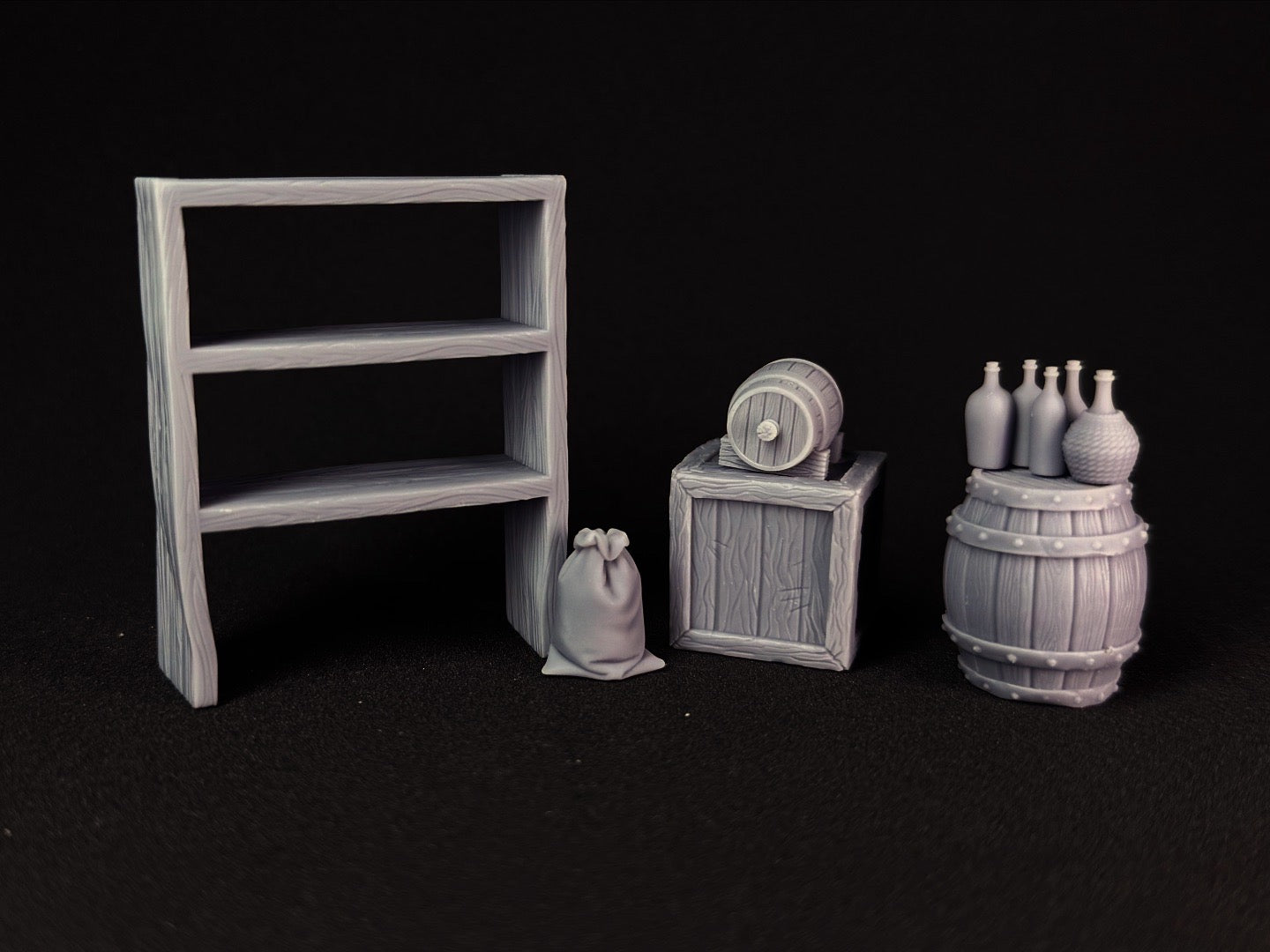 Set of miniature wooden furniture and props on a black background