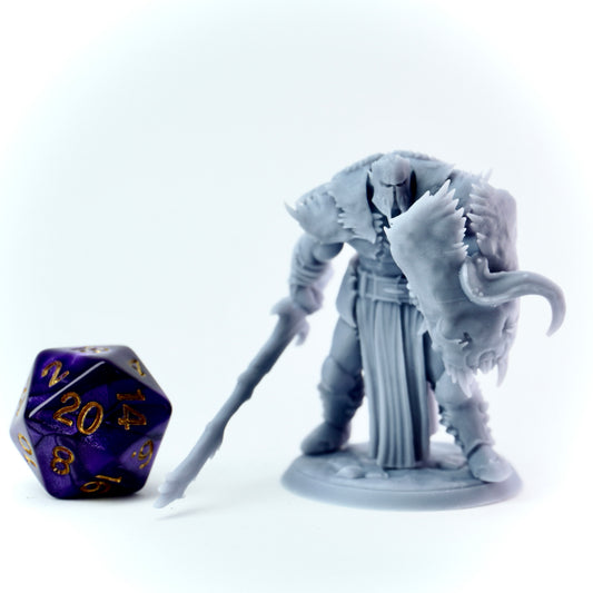 Gray fantasy figurine with a large weapon next to a purple polyhedral dice on a white background