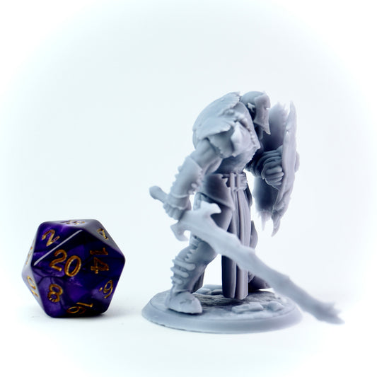 Gray fantasy figurine with a sword and shield next to a purple polyhedral dice on a white background