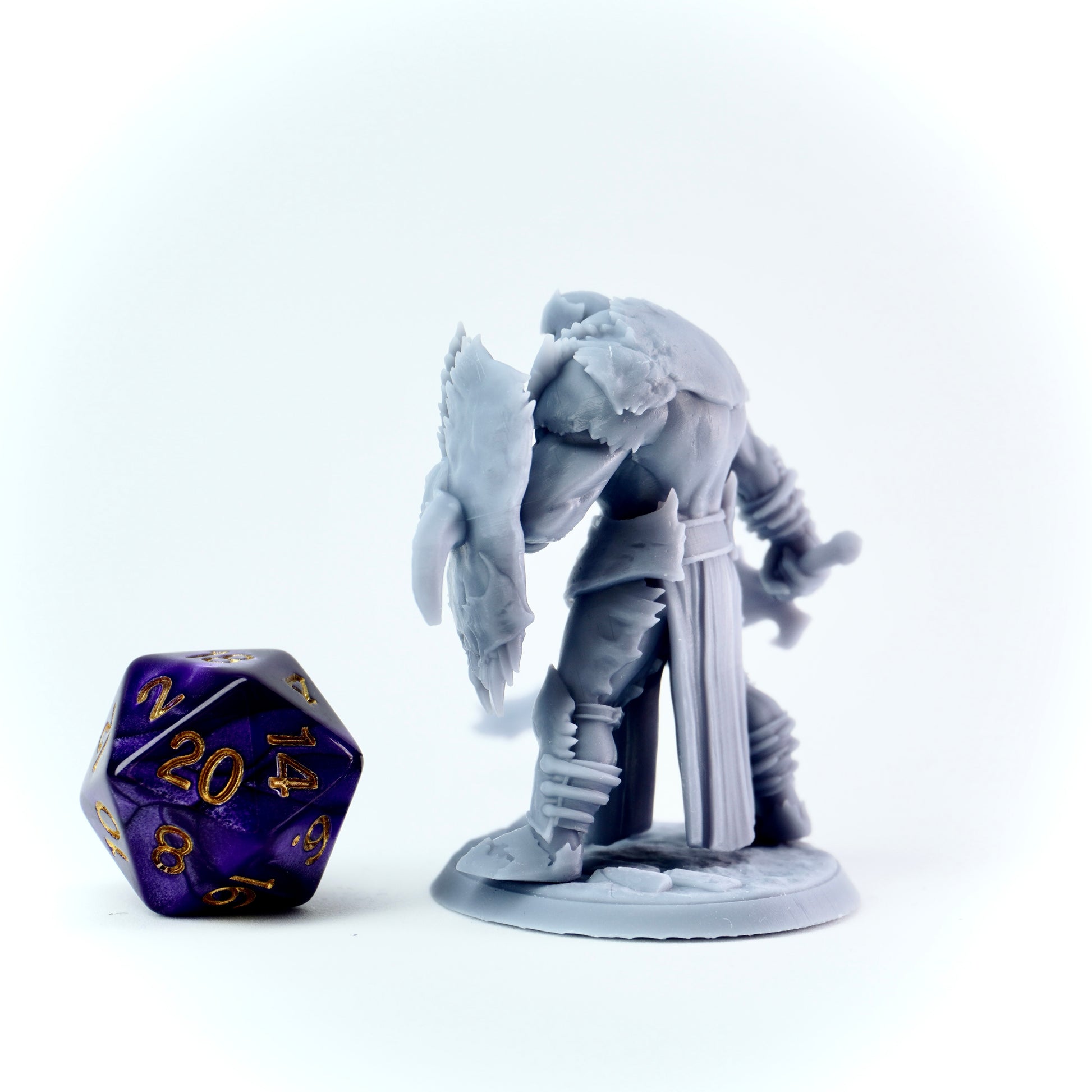 Gray knight fantasy figurine with a die on a white background
