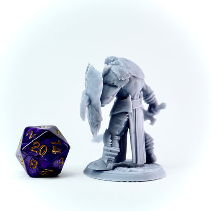 Gray knight fantasy figurine with a die on a white background