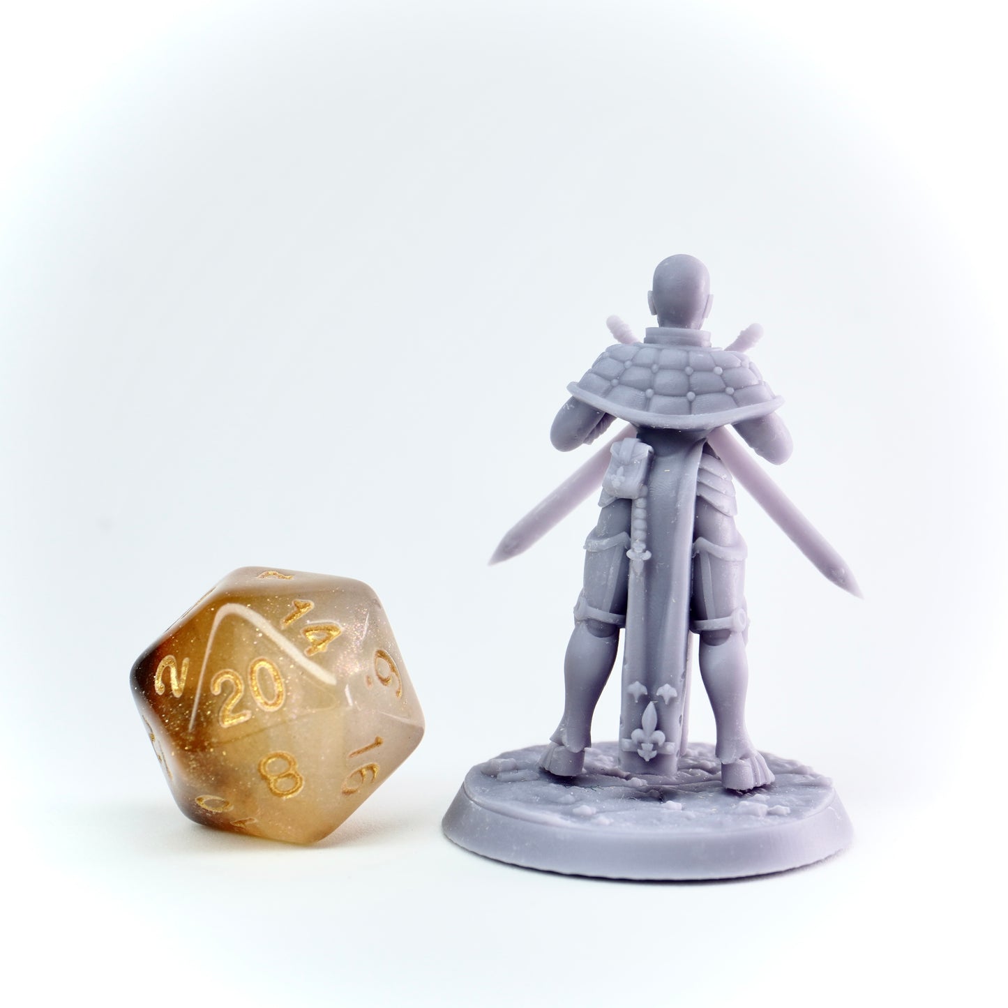 Gray fantasy figurine with a large gold die on a white background