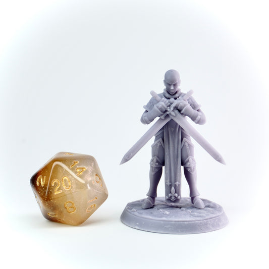 Gray miniature figure of a warrior holding two swords next to a gold polyhedral dice on a white background