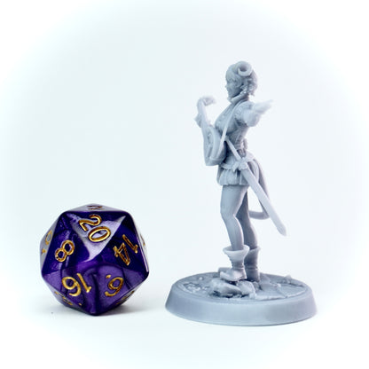 Gray miniature figurine of a female bard tiefling with a polyhedral dice on a white background