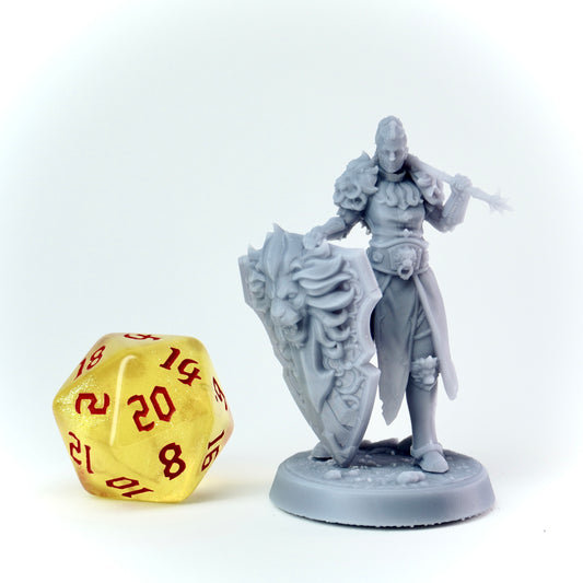 Gray fantasy figurine with a large yellow die featuring red text on a white background
