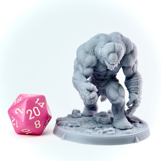 Gray monster figurine with a pink dice on a white background