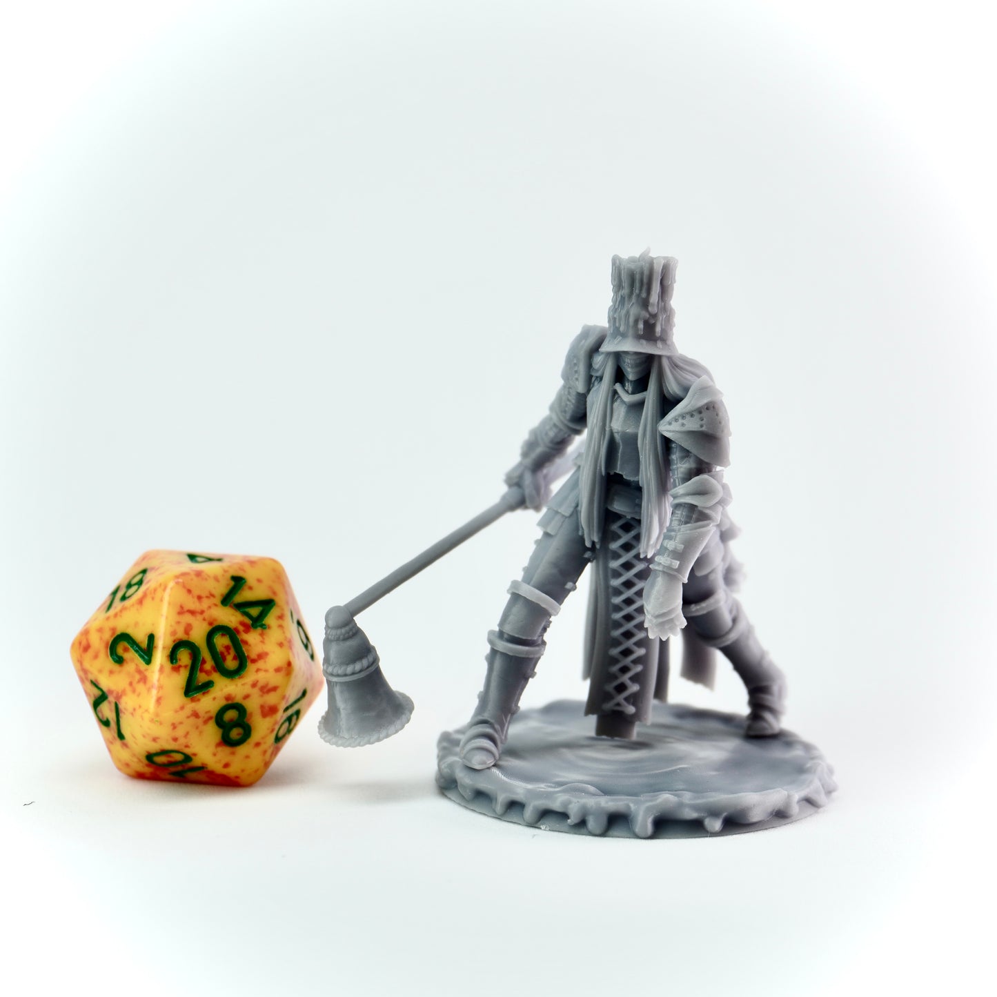 Gray miniature figure of a warrior with a large candle snuffer next to a d20 dice on a white background