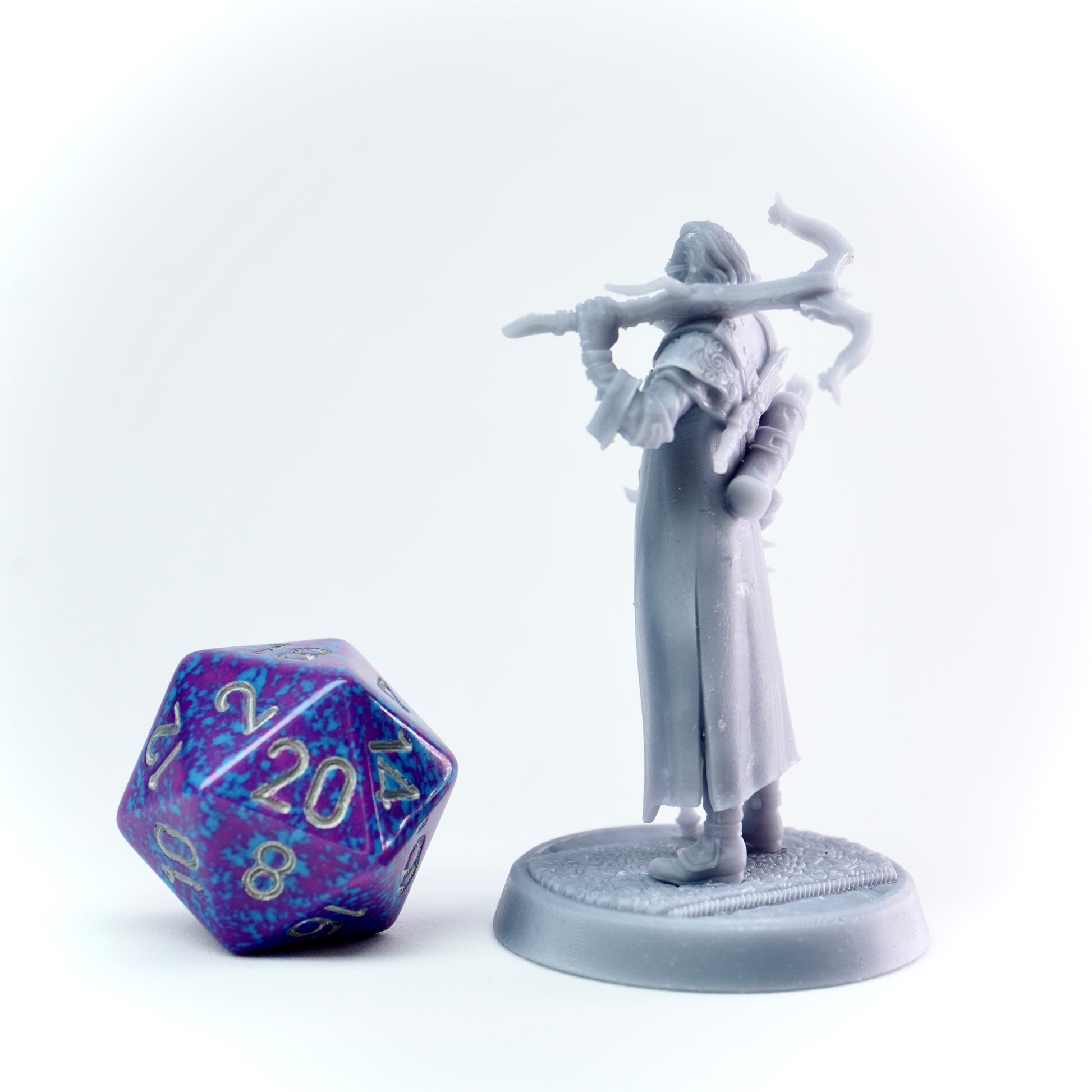 White fantasy figurine with a cane next to a polyhedral dice on a white background