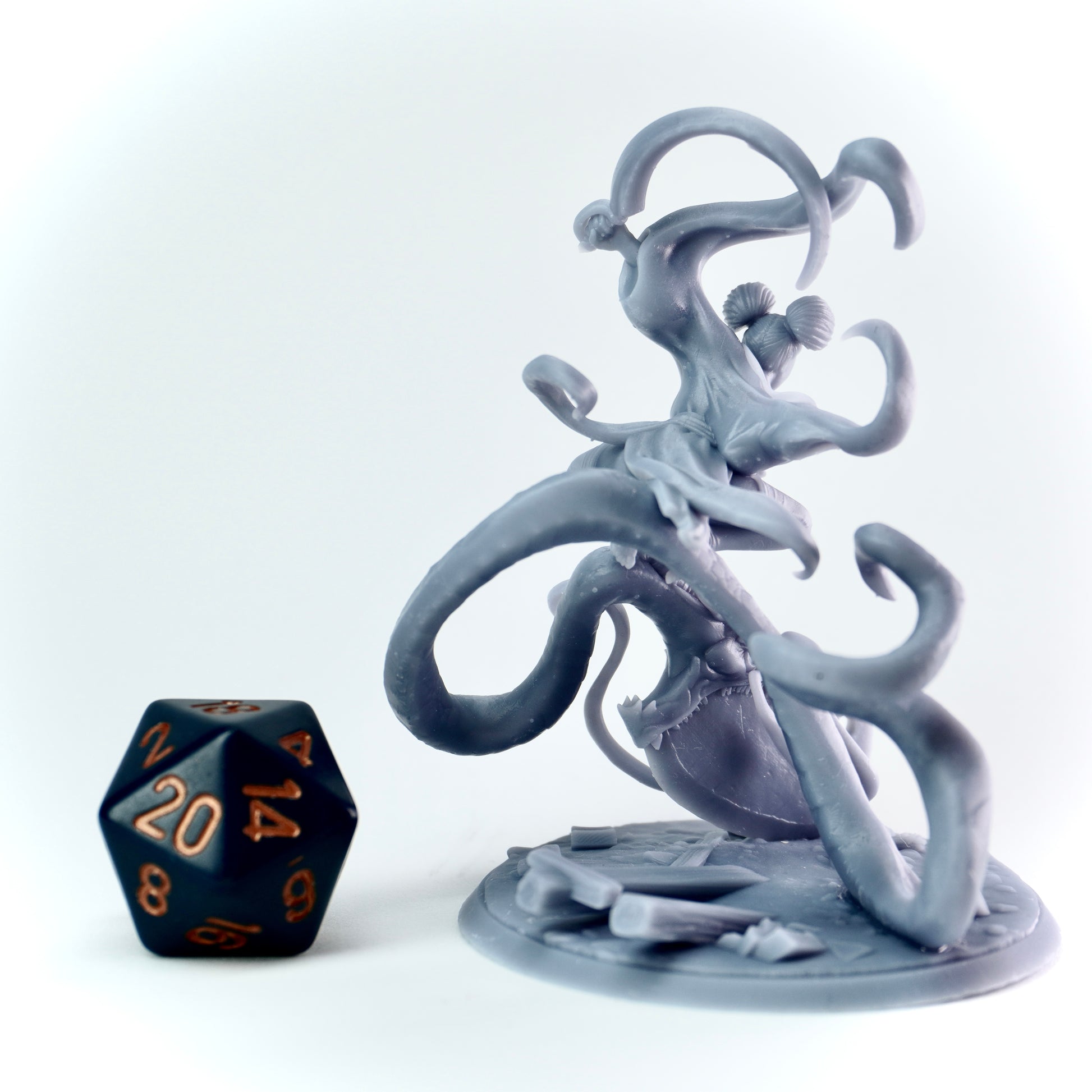 Gray fantasy figurine with a black polyhedral dice on a white background