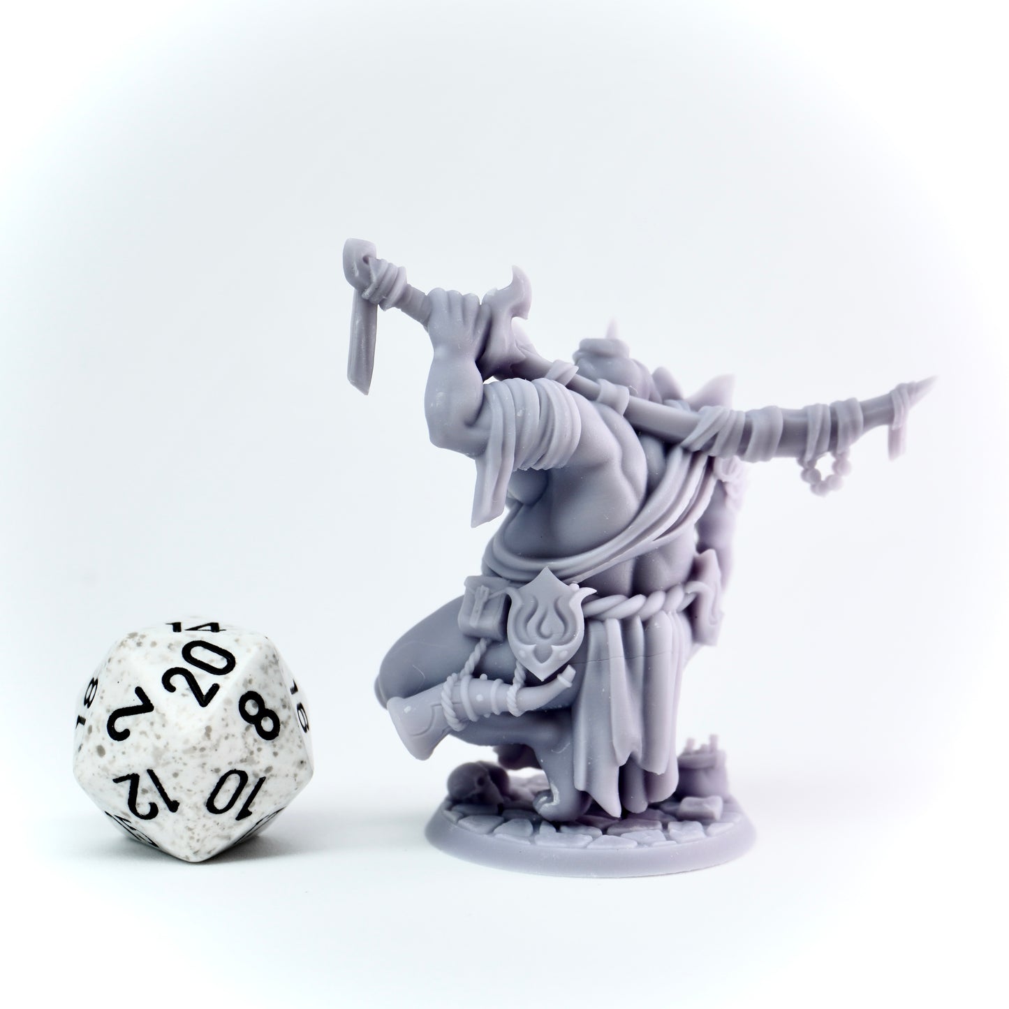 Gray fantasy figurine with a die on a white background