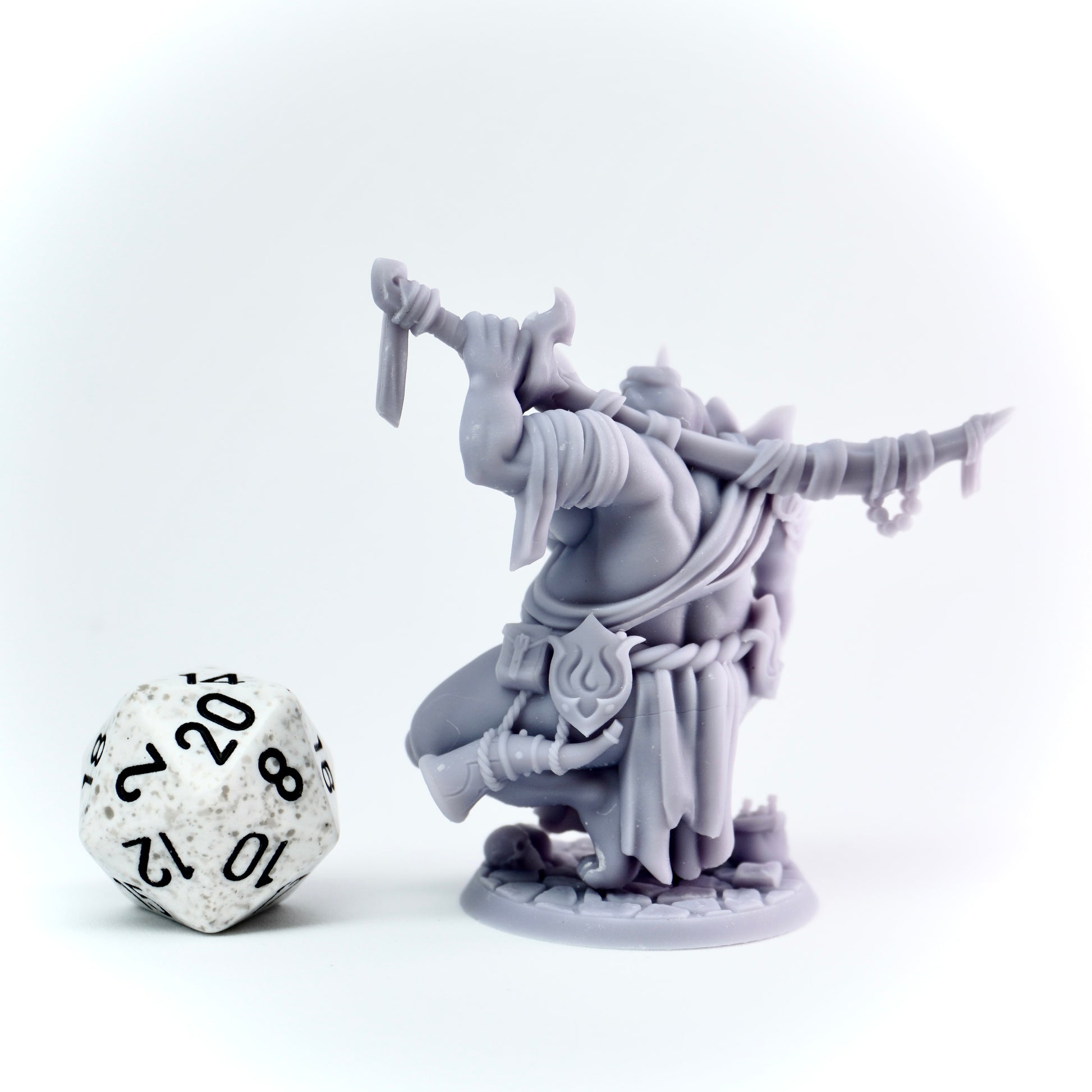 Gray fantasy figurine with a die on a white background