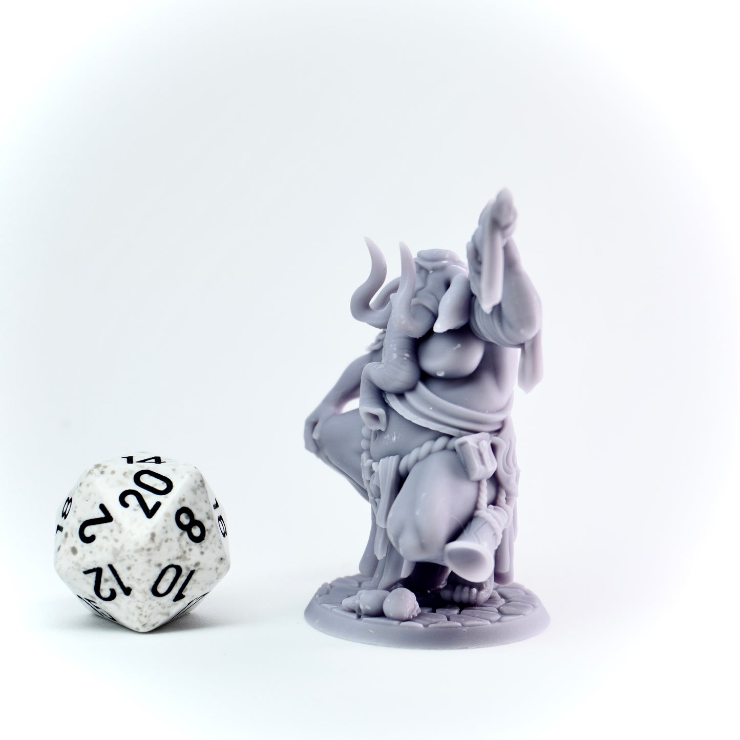 Gray elephant figurine with a die on a white background