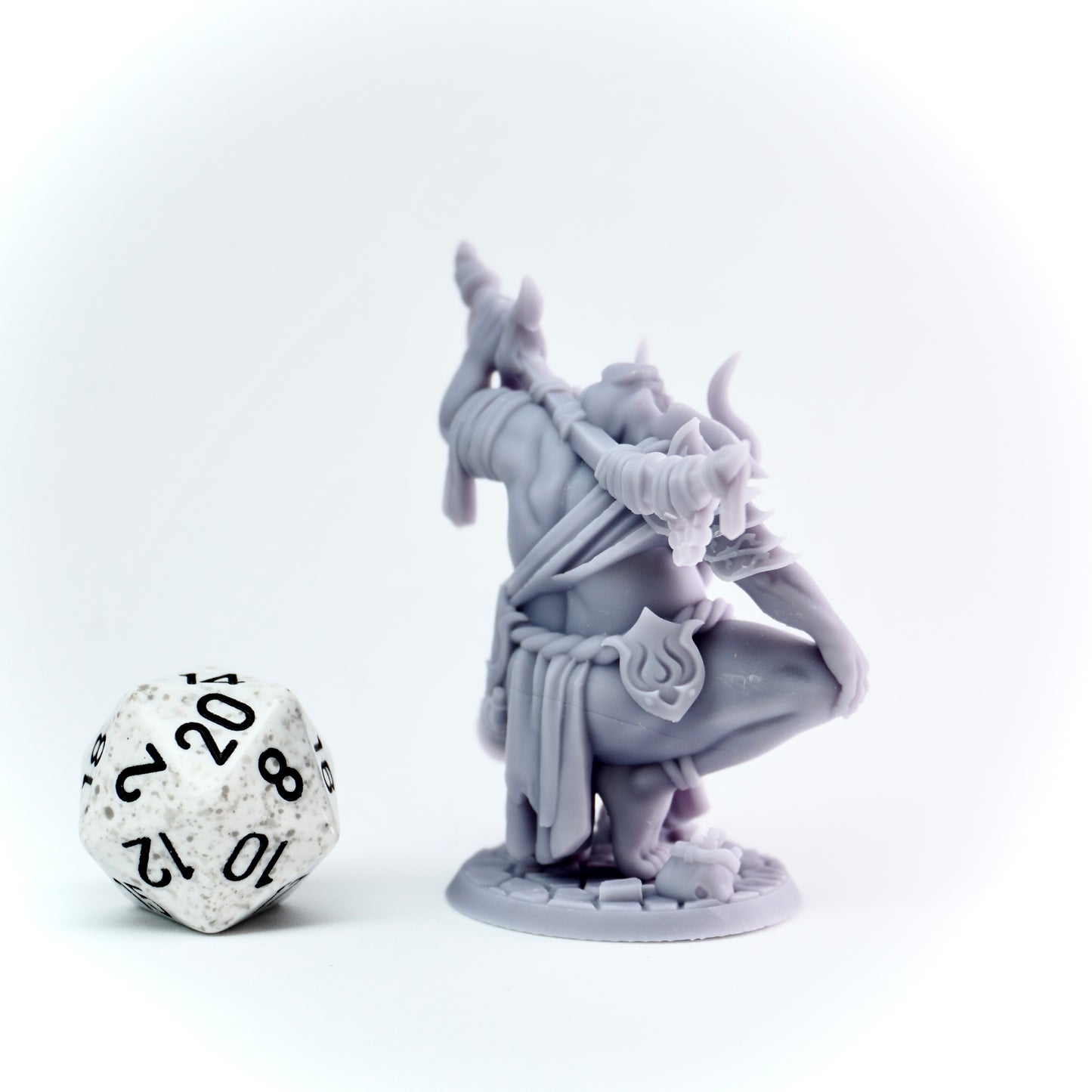 Gray fantasy figurine with a large die on a white background
