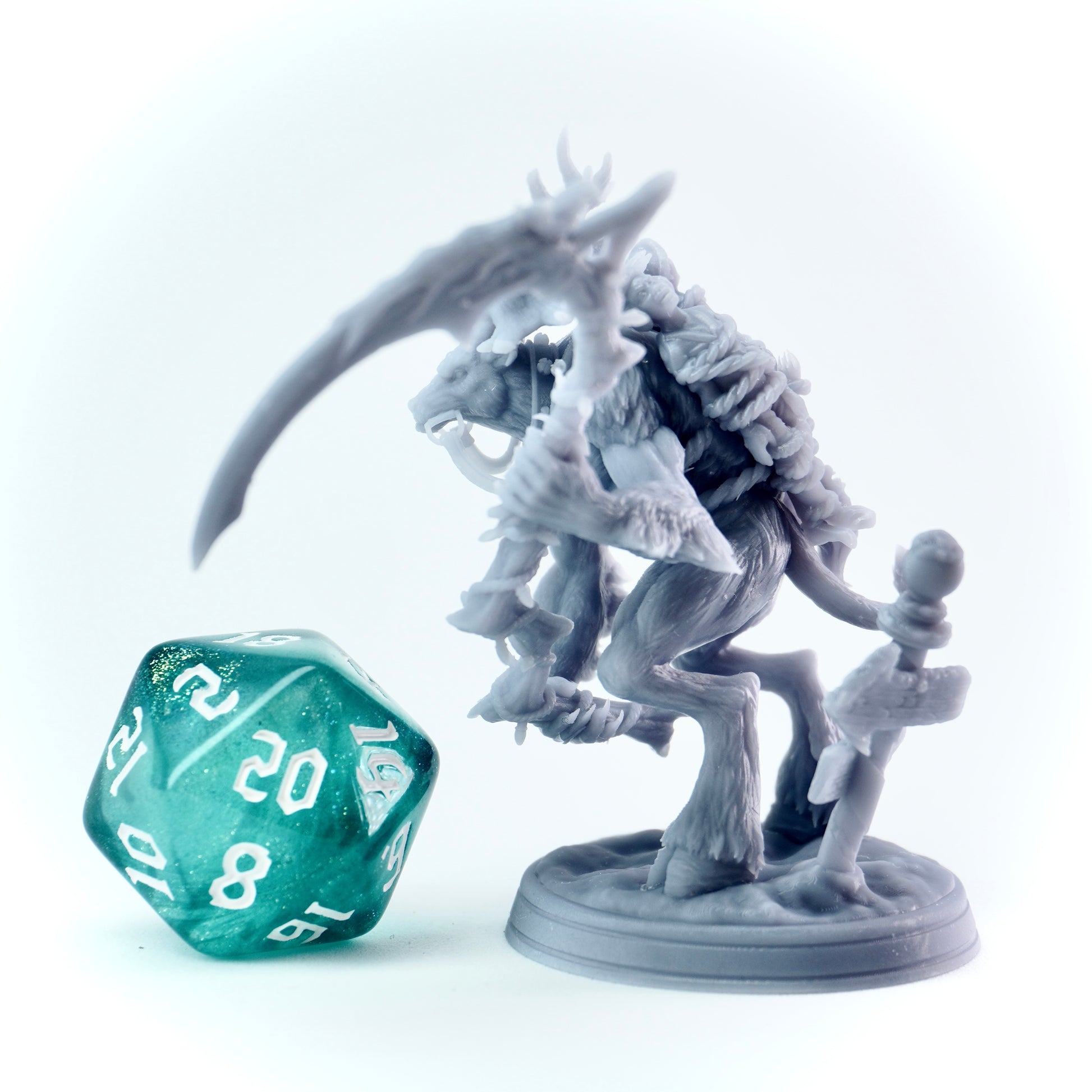 Gray deer-like fantasy creature figurine with a green polyhedral dice on a white background