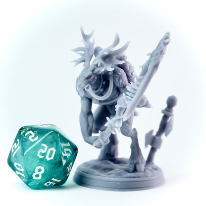 Gray fantasy figurine with antlers and a spear next to a green polyhedral dice on a white background
