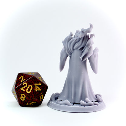 Gray cultist figurine next to a polyhedral dice on a white background