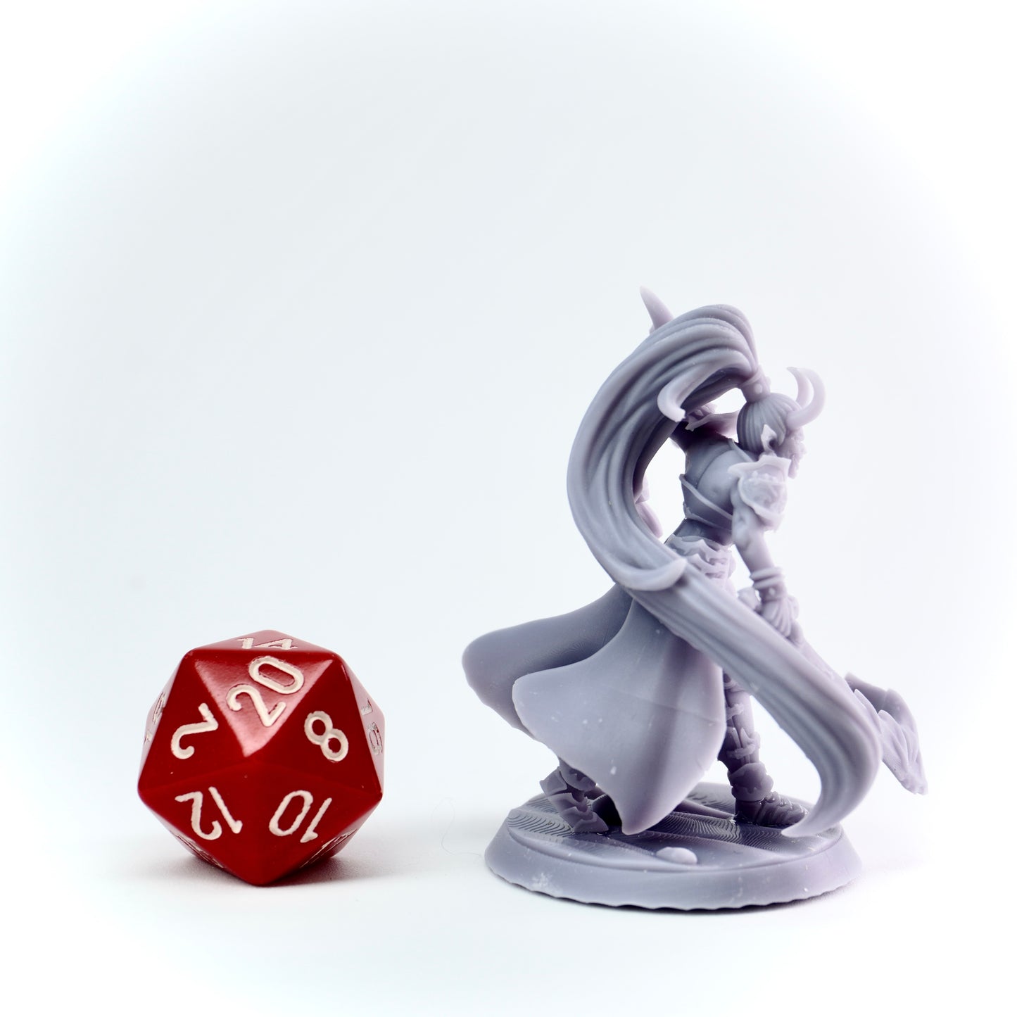 Gray fantasy figurine with a red polyhedral dice on a white background