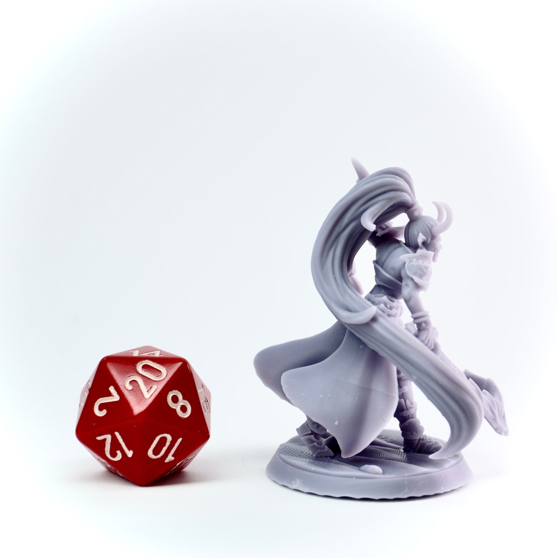 Gray fantasy figurine with a red polyhedral dice on a white background