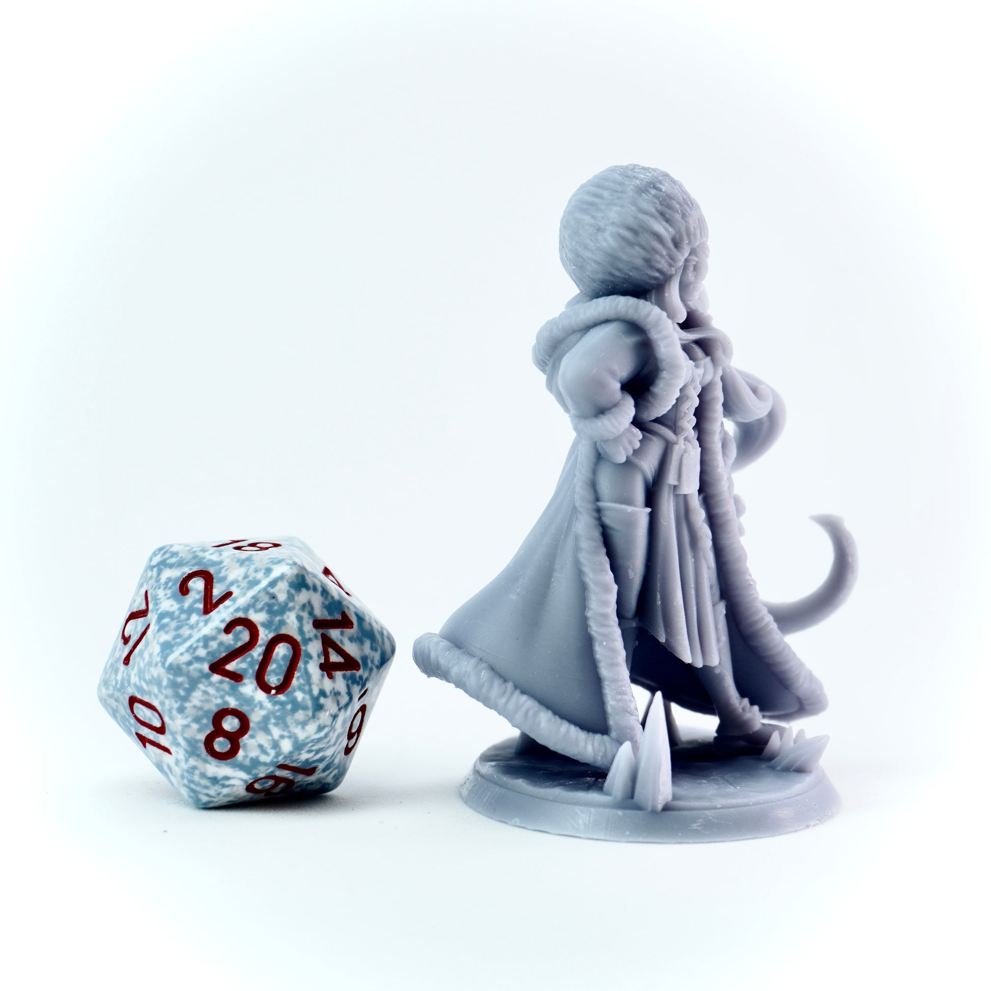 Gray miniature figure of a female character with a large die on a white background