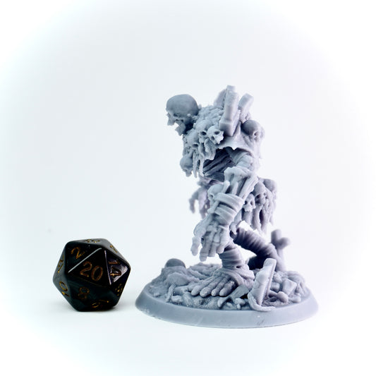 Gray miniature figurine of a skeleton with a black polyhedral dice on a white background
