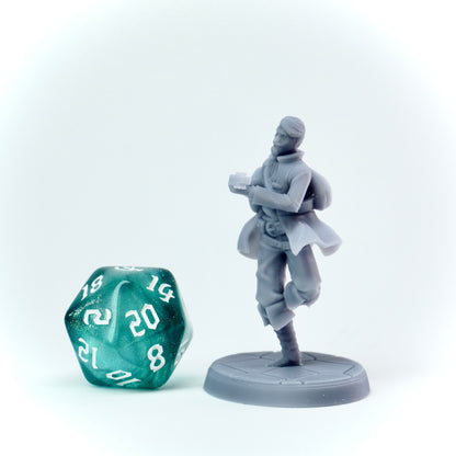 Gray miniature figure of a character holding a lute next to a green polyhedral dice on a white background