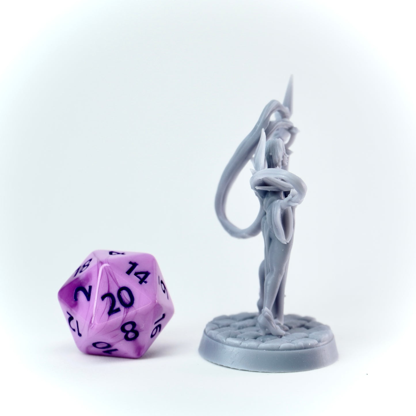 Purple polyhedral dice and gray figure on a white background