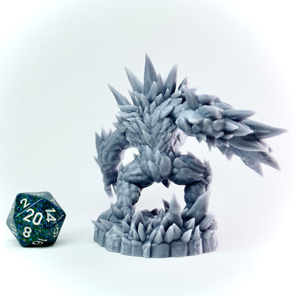 Gray fantasy figurine with spiked details next to a blue polyhedral dice on a white background