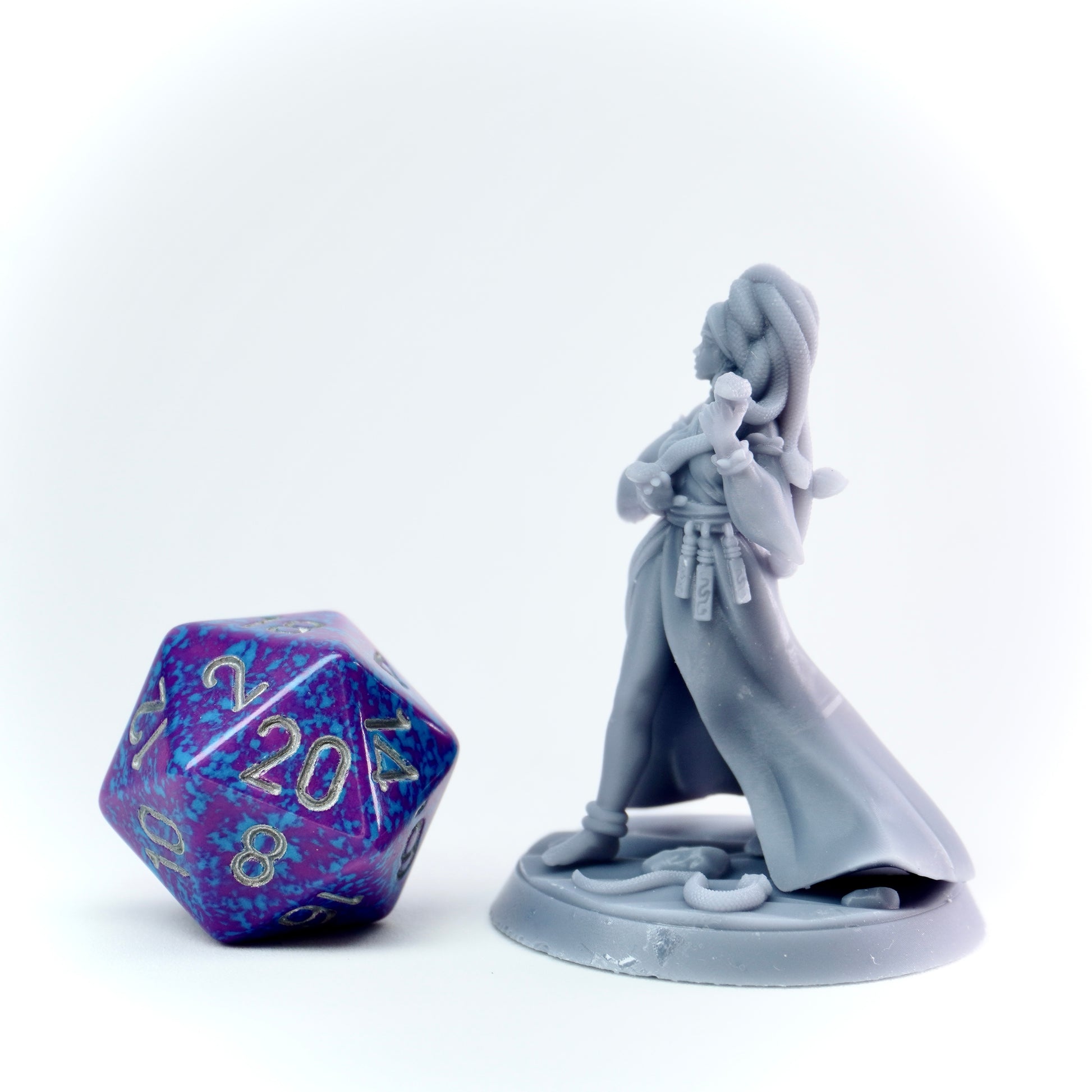 Gray fantasy figurine with a large polyhedral dice on a white background