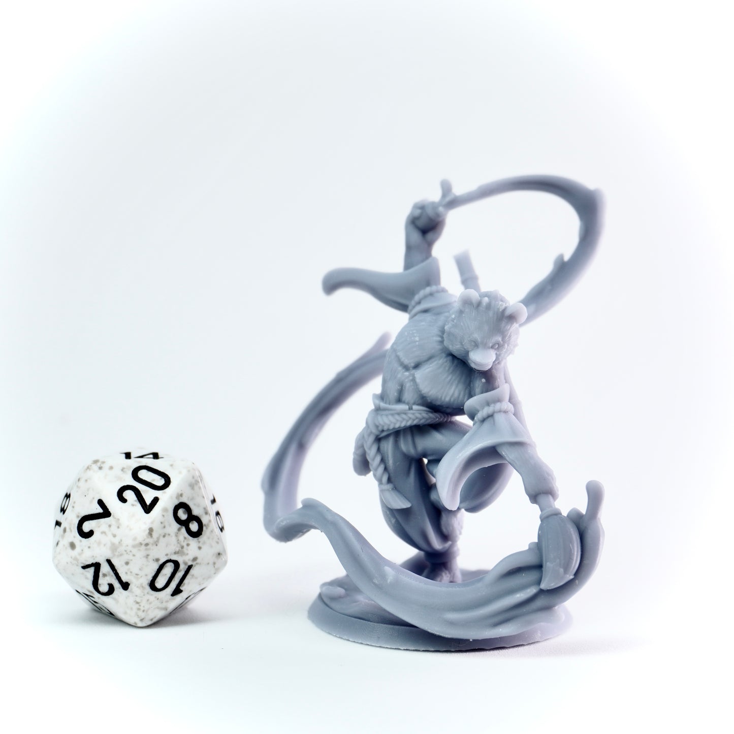 Gray fantasy figurine on a white background with a 20-sided die.