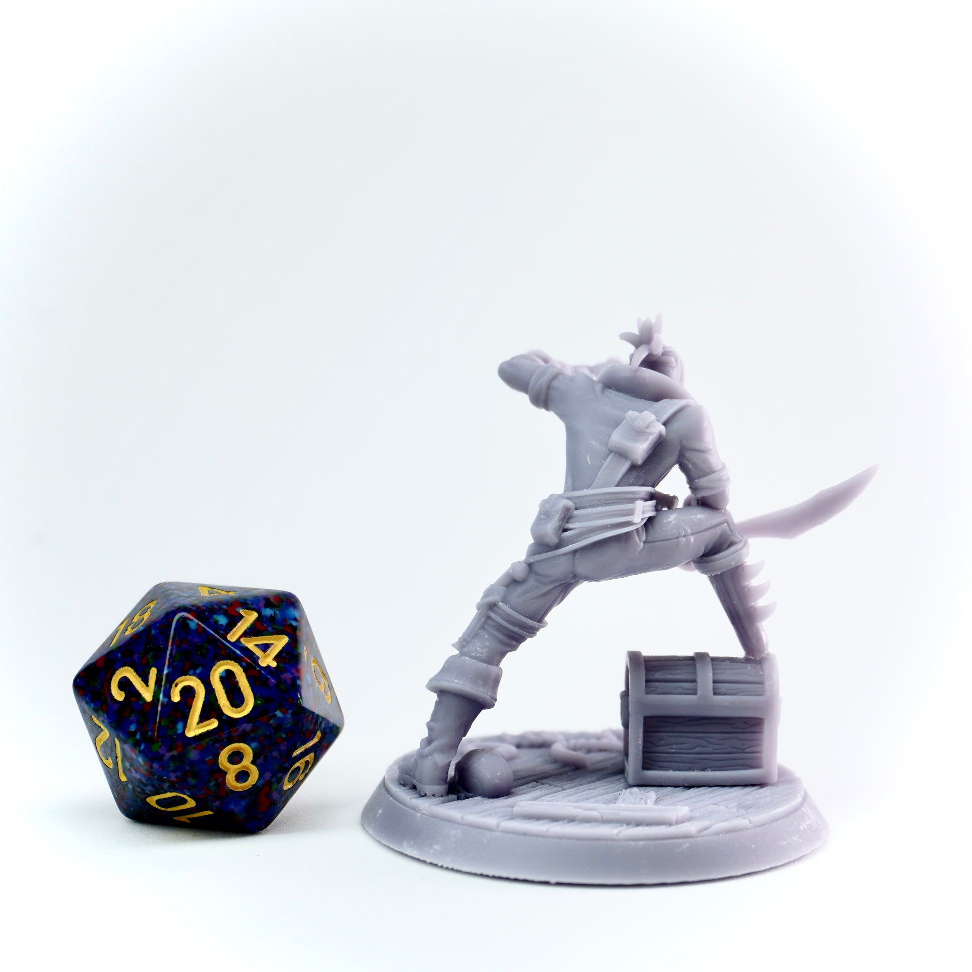 Gray miniature figure of a warrior with a sword next to a D20 dice on a white background