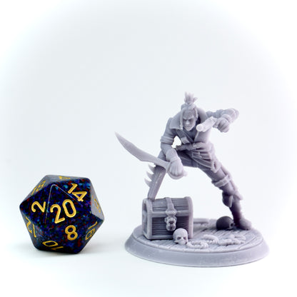 Gray miniature figurine of a warrior with a sword, next to a treasure chest and skull, on a white background.