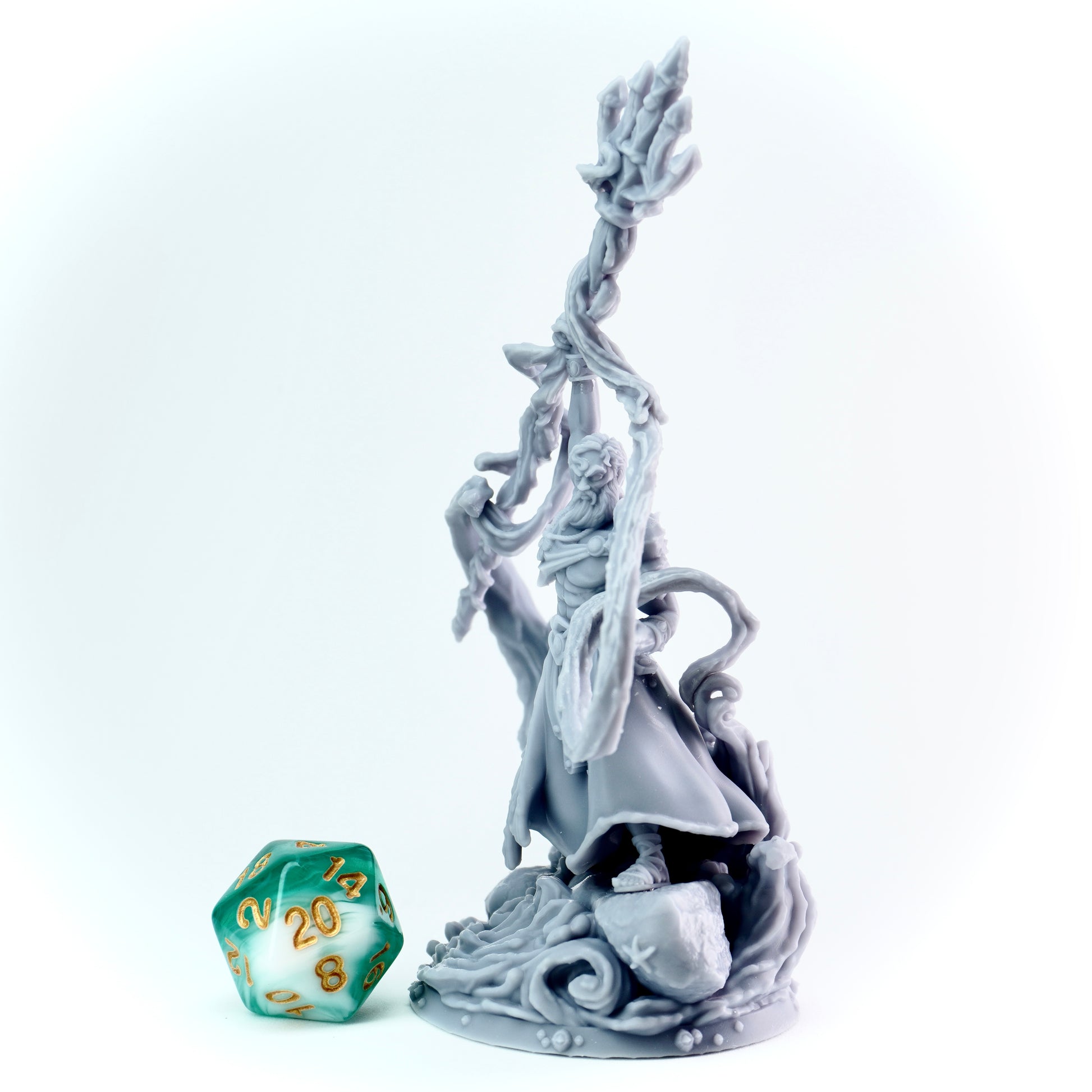 Gray figurine of a warrior with a trident, next to a green polyhedral dice on a white background