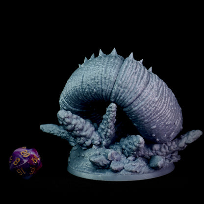Gray purple worm monster creature figurine on a black background