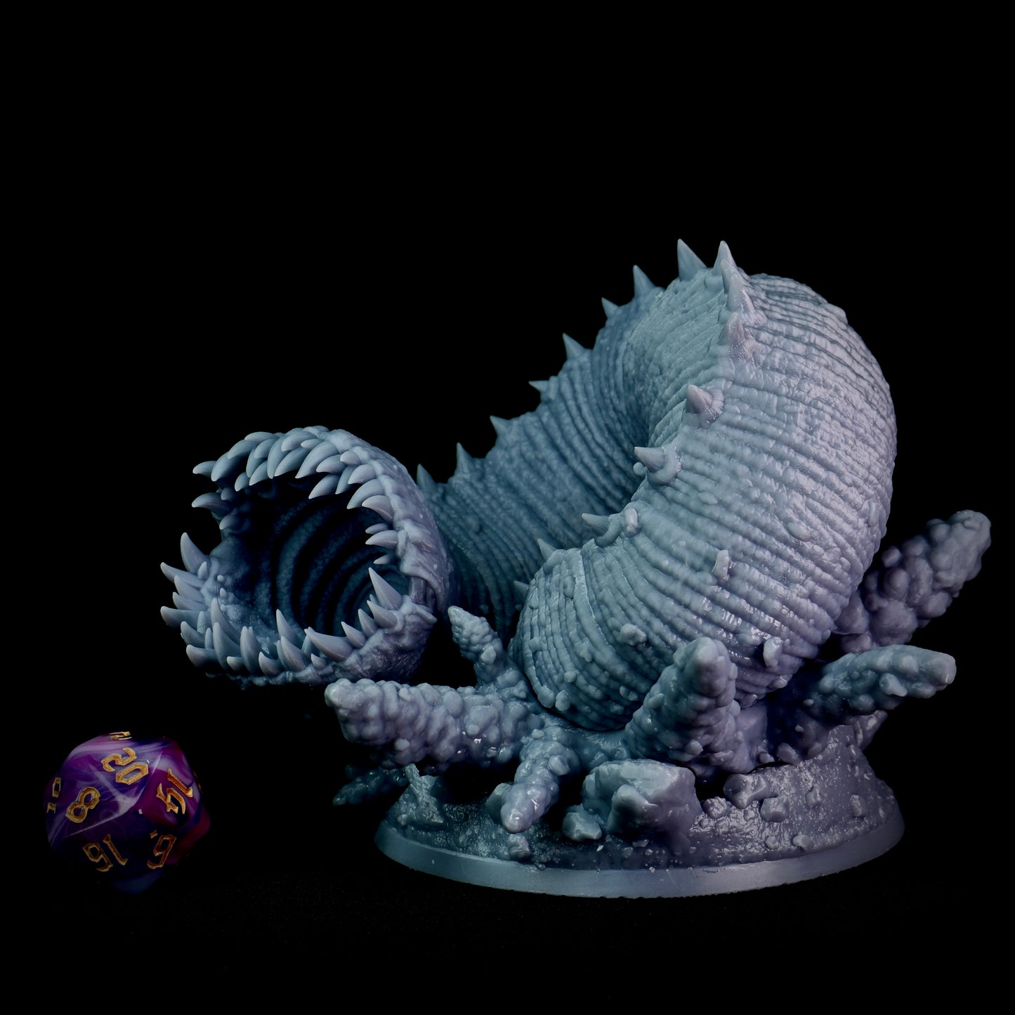 Monster figurine with a large mouth and spiky texture on a black background