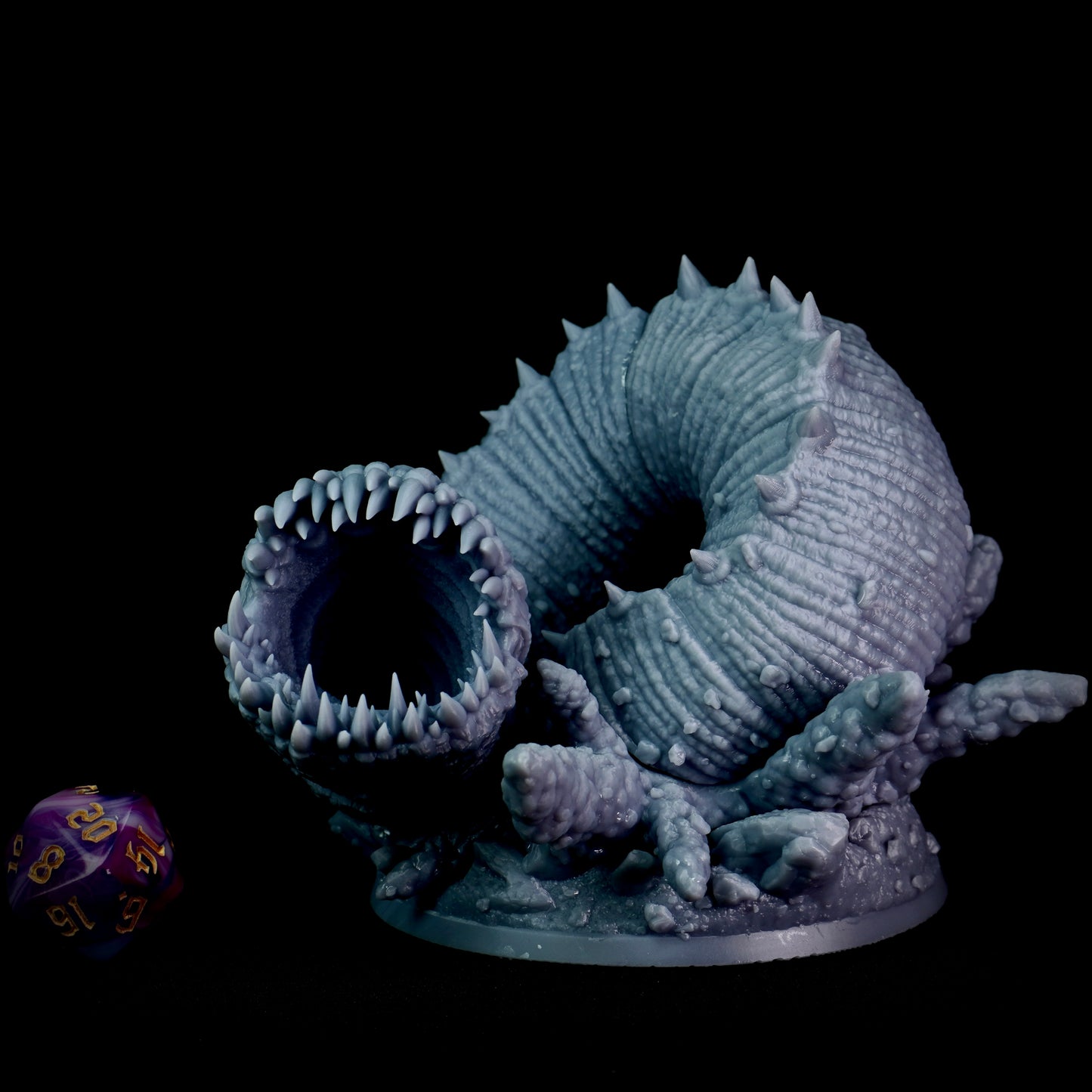 Monster figurine with large mouth and spikes on a black background