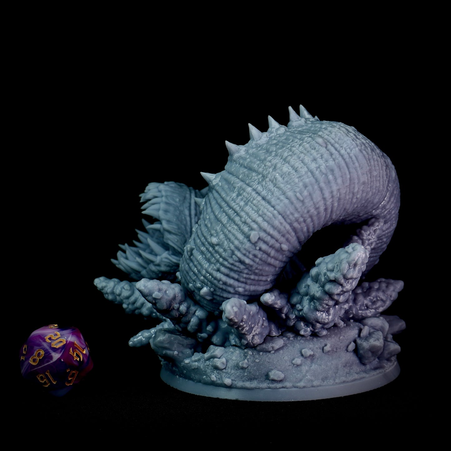 Decorative purple worm figurine with a purple and blue color scheme on a black background