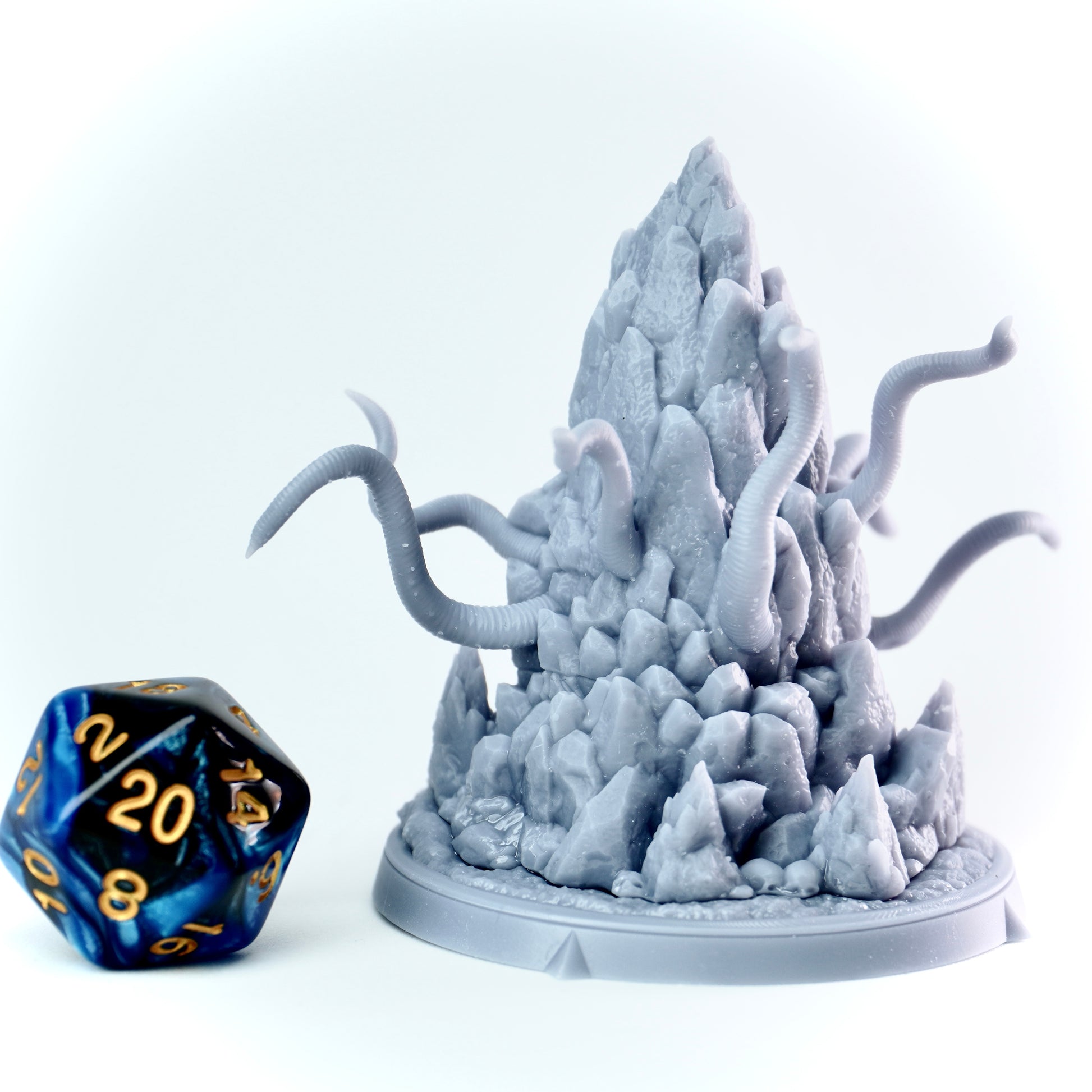 Frostgrave-style miniature with tentacles and d20 die on a white background