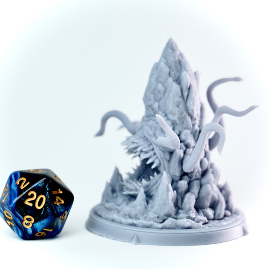Stone minic-style miniature with rocky landscape and blue dice on a white background