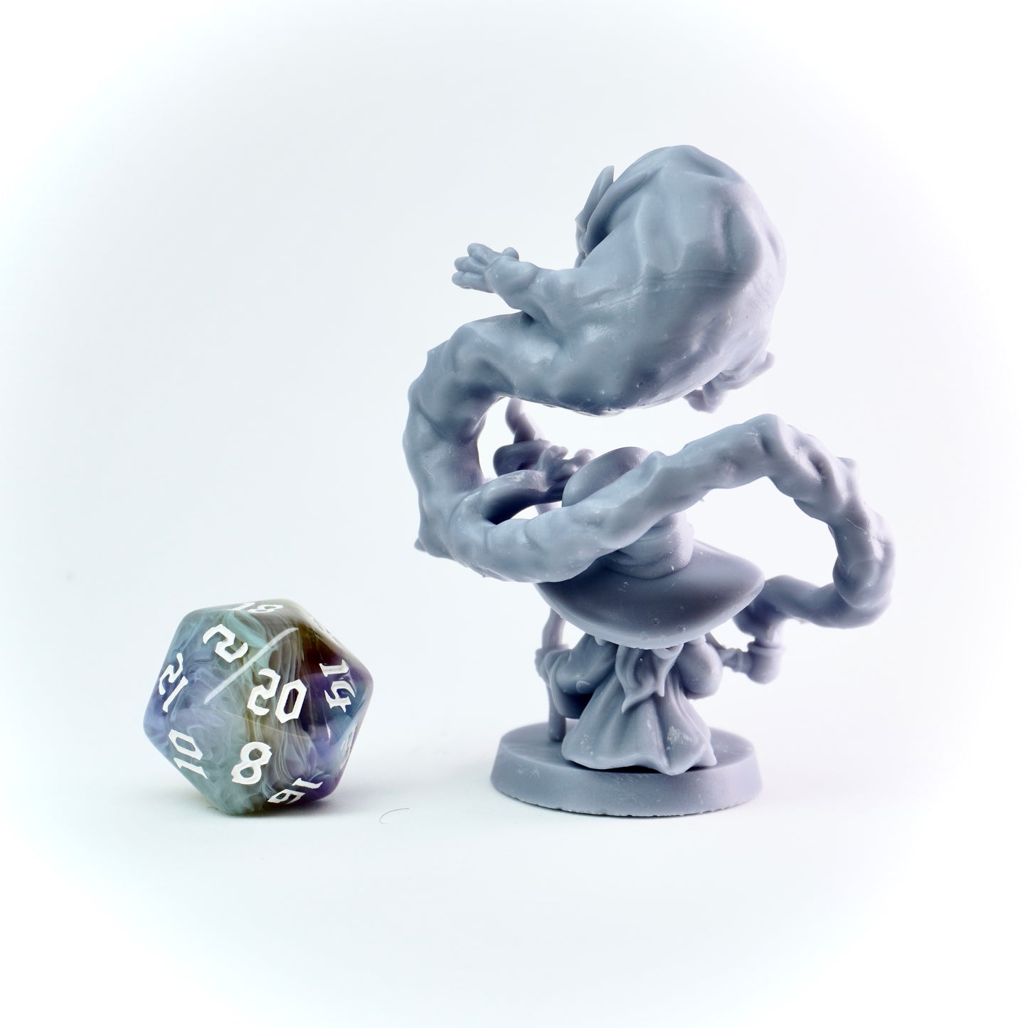 Gray fantasy figurine on a white background with a D20 polyhedral dice.