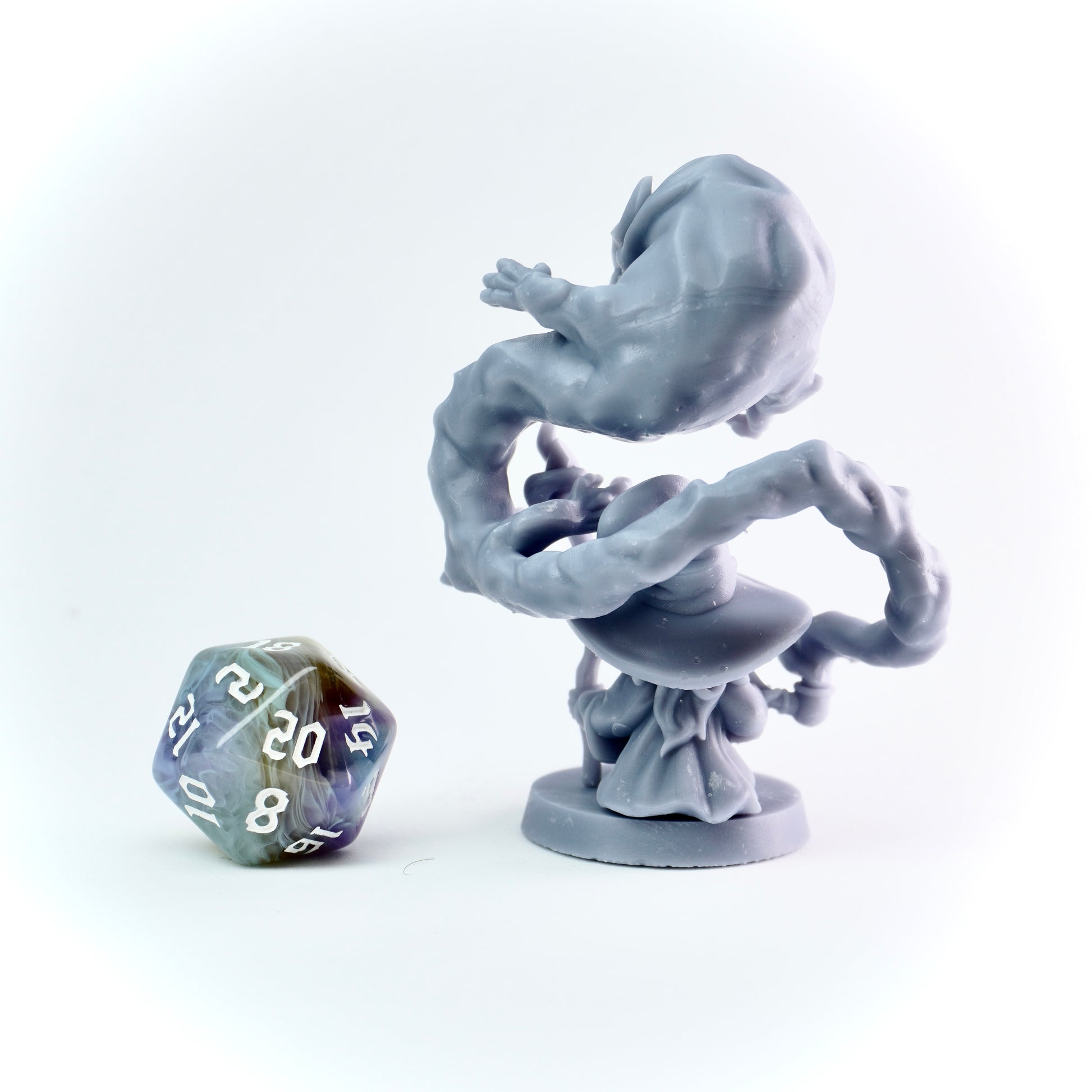 Gray fantasy figurine on a white background with a D20 polyhedral dice.