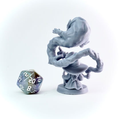 Gray fantasy figurine on a white background with a D20 polyhedral dice.