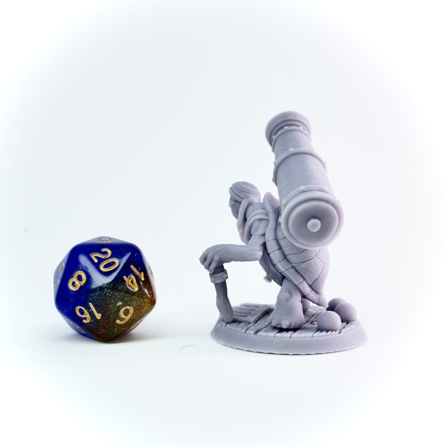 Gray fantasy figurine and blue and gold polyhedral dice on a white background