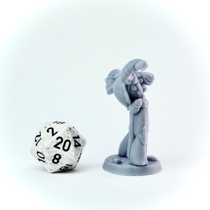 Gray miniature figure with a staff next to a twenty-sided die on a white background