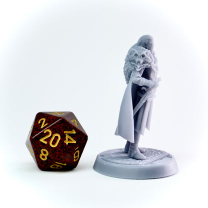 Gray figurine of a noble character next to a large polyhedral dice on a white background