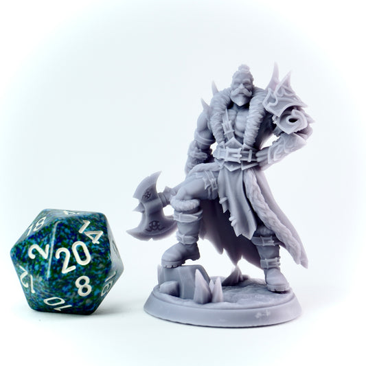Gray fantasy barbarian figurine with a large axe next to a 20-sided die on a white background