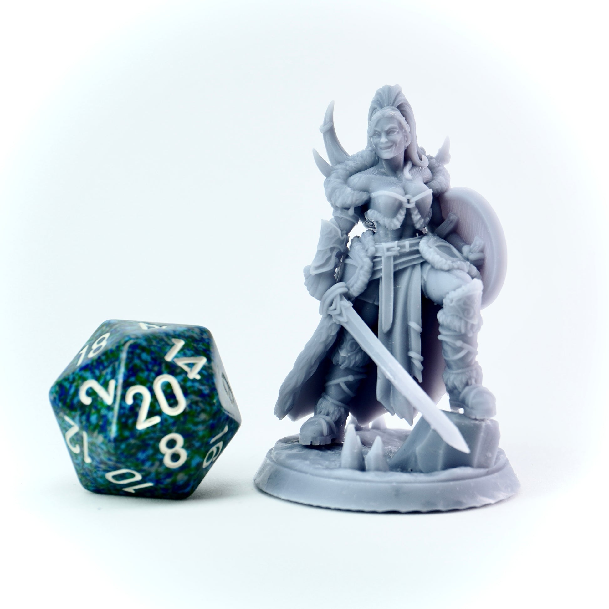 Gray fantasy viking female figurine with a sword next to a D20 dice on a white background